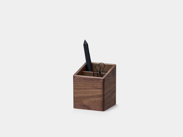 Wooden pen holder with a black pen on a light gray background| walnut