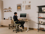 Person sitting at a desk in a home office setting with a computer monitor. |light oak, , 