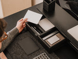 Person organizing items on a desk with a focus on stationery and technology. drawer organisers wood | black, 