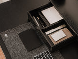 Desk setup with a black stationery set, mouse pad, and keyboard.  | black, 