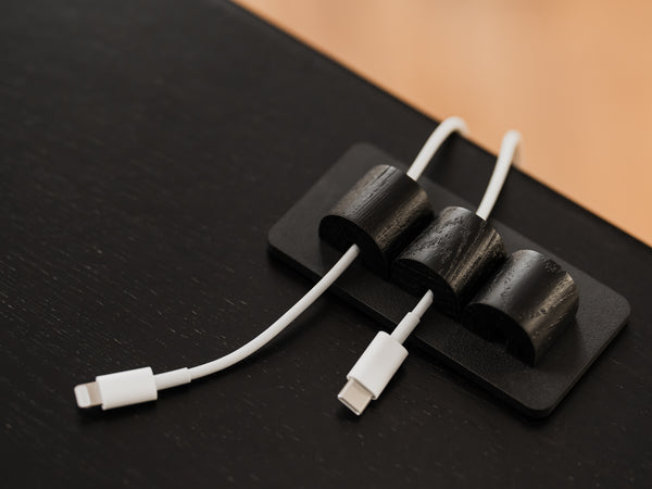 White USB-C cables on a black surface with a brown background | black, 