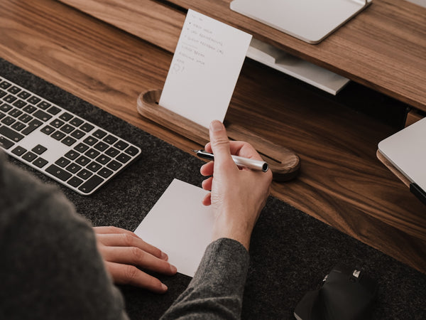 Person taking notes at a desk with oakywood to-do desk kit | walnut