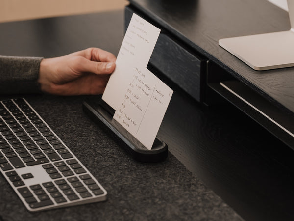 Person using an analog to-do system on a desk with a great setup keyboard and computer mouse. |-