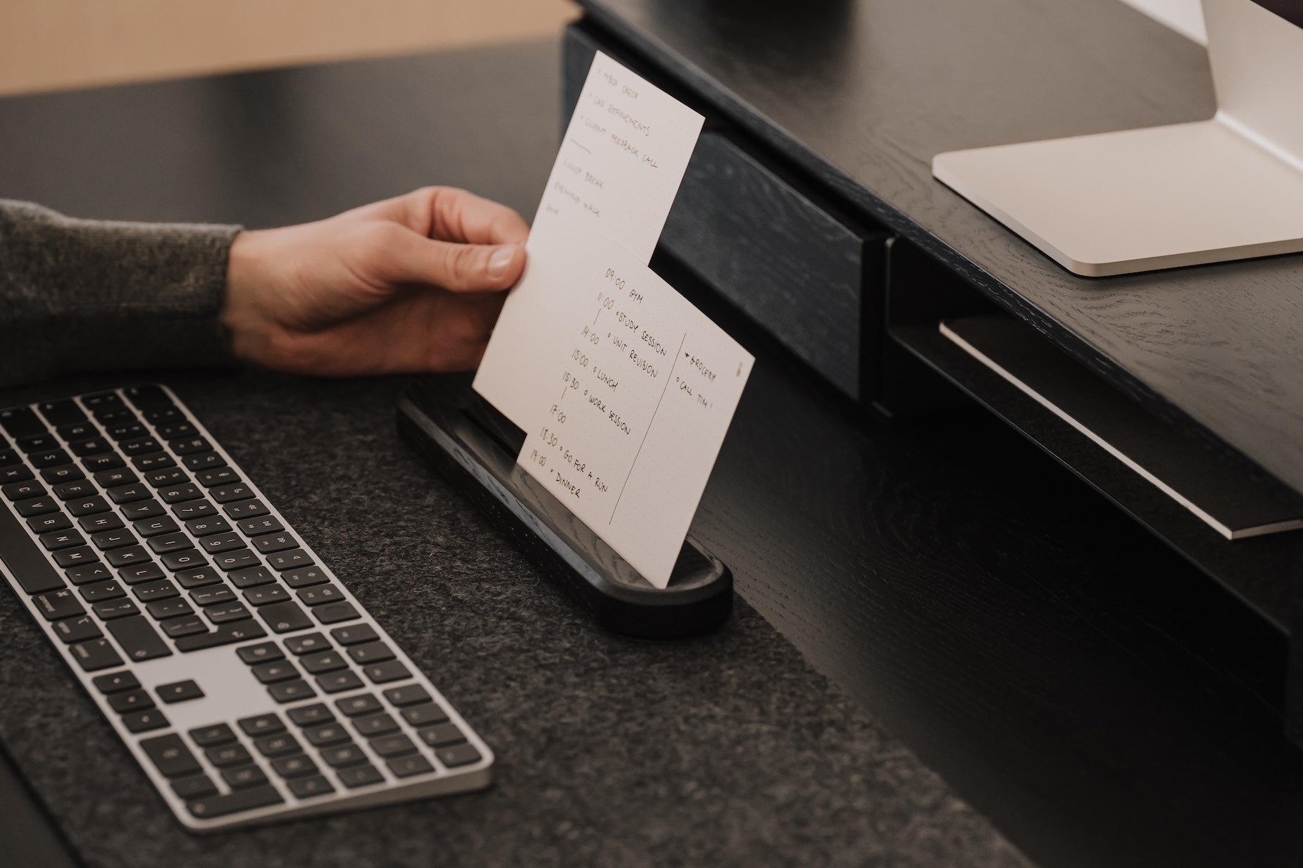 Person using an analog to-do system on a desk with a great setup keyboard and computer mouse. |-