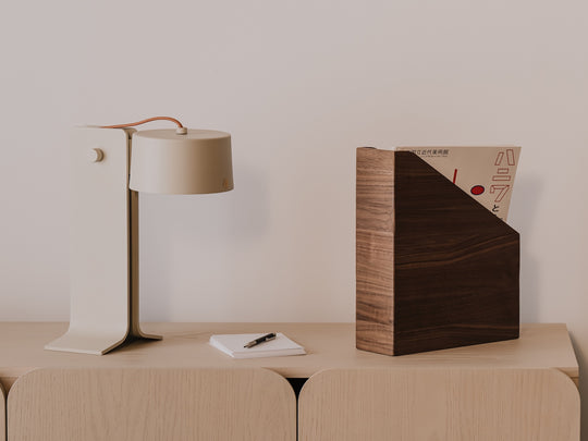 Modern lamp, notebook, and wooden magazine paper holder with a minimalistic background  | walnut