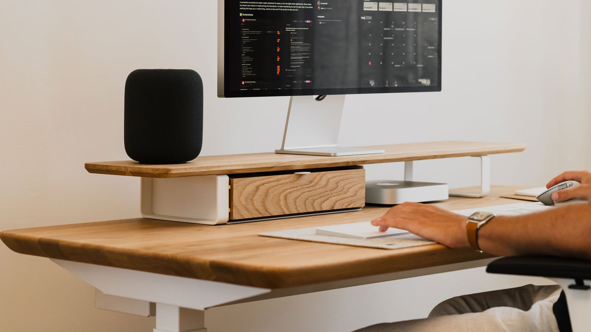 Male sitting in front of the desk with desk shelf on it